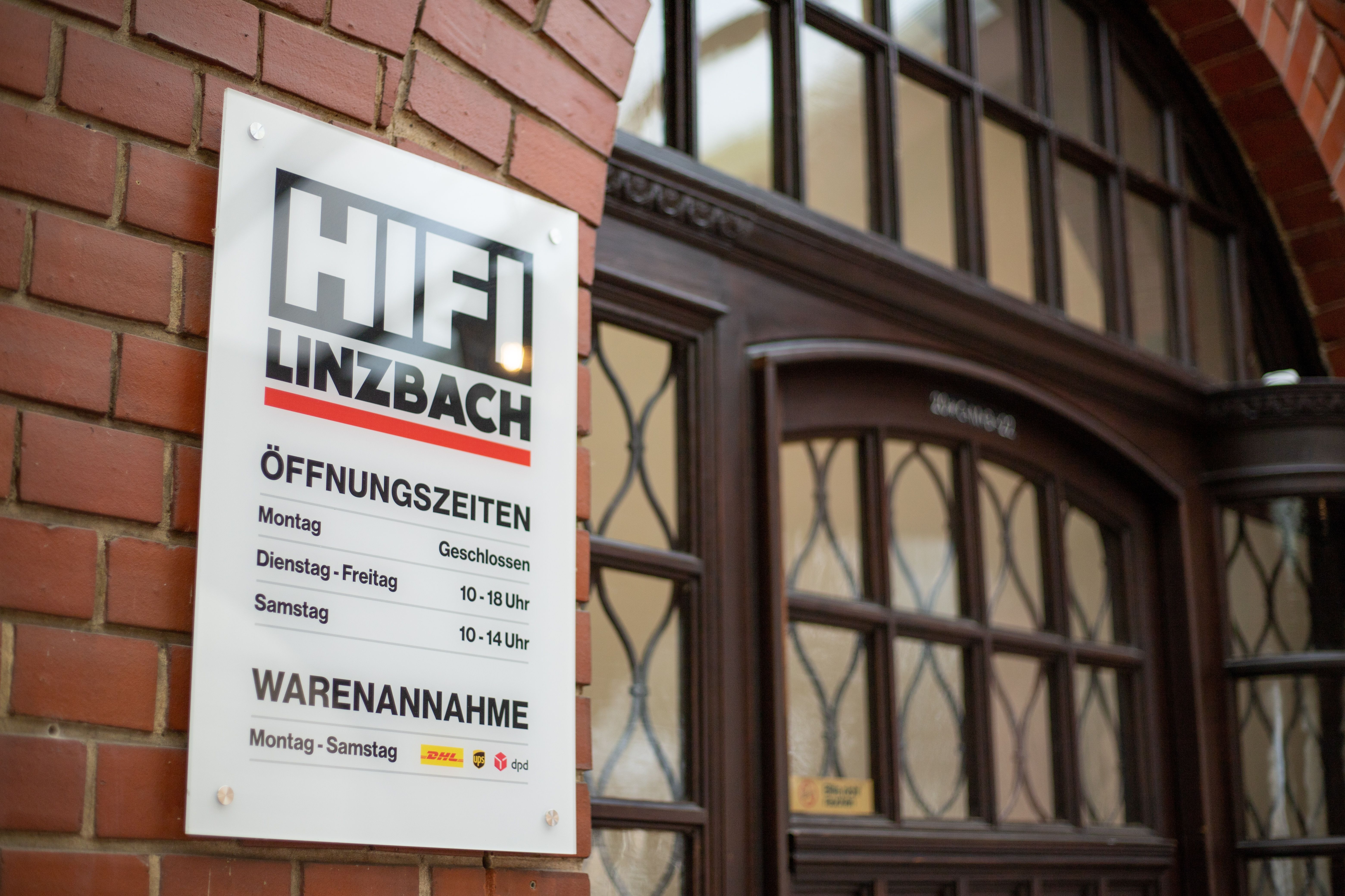 Öffnungszeiten Schild an der Hausfassade